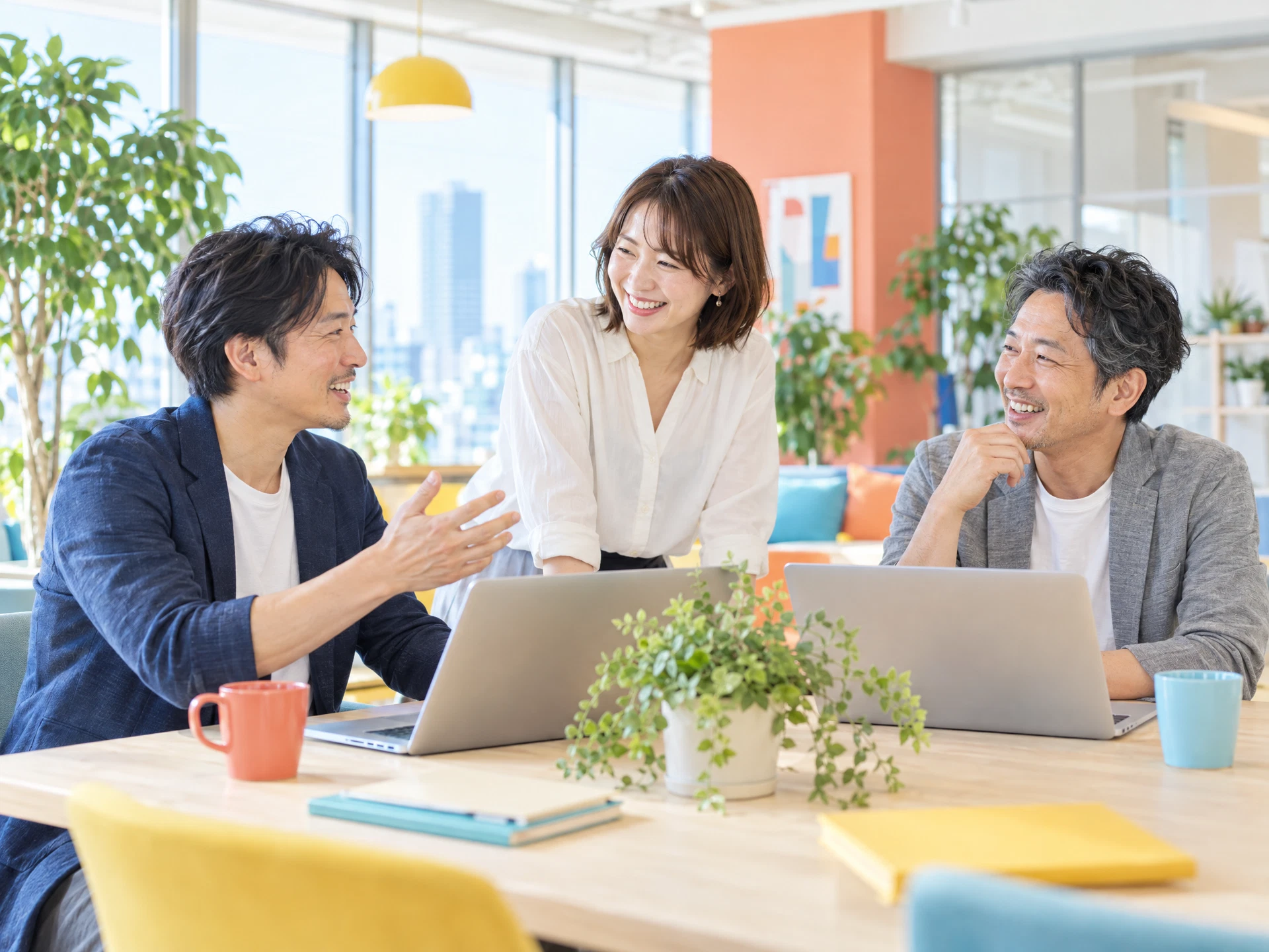 明るいオフィスでノートパソコンを囲んで打ち合わせをするマスタープランのスタッフ